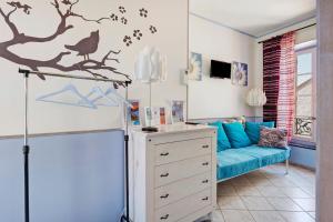a living room with a blue couch and bird decals on the wall at Le Clos Mazerolles in Cruzy