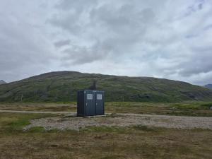 a black box in the middle of a field with a hill at Stafafell Ready Tents in Stafafell