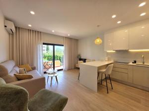 a kitchen and living room with a couch and a table at Apartamentos Mar-Sol Villas in Vilamoura