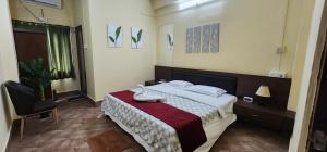 a bedroom with a bed and a chair in it at Hotel Roy's in Shādipur