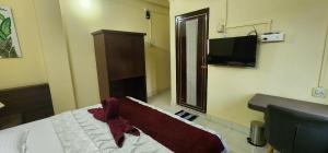 a bedroom with a bed and a flat screen tv at Hotel Roy's in Shādipur