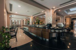 a kitchen with a bar with chairs and tables at Golden Tulip Bahrain in Manama +78 photos