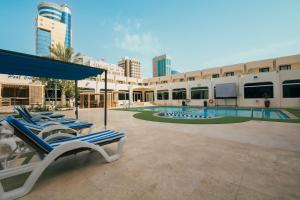 a resort with lounge chairs and a swimming pool at Golden Tulip Bahrain in Manama