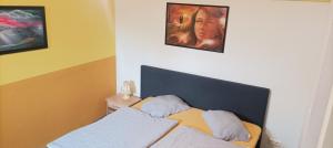 a bedroom with a bed and two pictures on the wall at Pension Johnnys in Görlitz