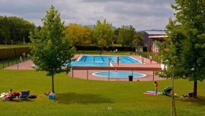 a large swimming pool with people in a park at Casa Eleizpe by Next Stop Bilbao in Ergoyen