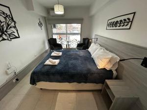 a bedroom with a bed and two chairs and a window at Apart Luro VI in Santa Rosa