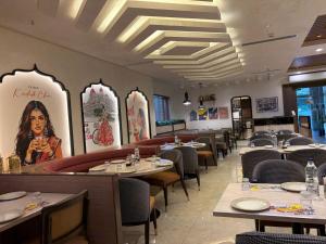 a dining room with tables and chairs in a restaurant at Hotel Sudha Brahma in Tirupati