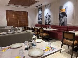 a restaurant with tables and chairs and a red couch at Hotel Sudha Brahma in Tirupati +20 photos