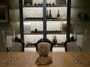 a table with two wine glasses and a bust on it at Stipa Boutique Hotel in Chacras de Coria +16 photos