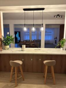 a kitchen with two stools in front of a counter at Stai Ca Acasă in Slănic-Moldova