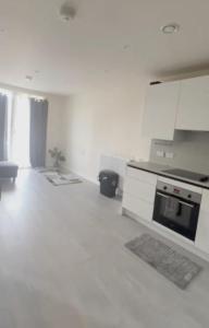 a white kitchen with a stove and a microwave at Harrow Nest - 1Bedroom in Hatch End +1 photo
