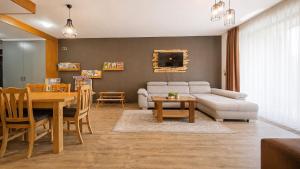 a living room with a couch and a dining room at TIAM Apartment Poiana Brașov D117, 3 rooms, 3 terraces, 3 bathrooms in Poiana Brasov