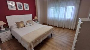 a bedroom with a bed and a red wall at La casa de Hio in Hio