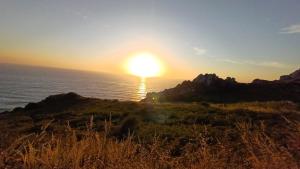 a sunset over the ocean with the sun setting at La casa de Hio in Hio
