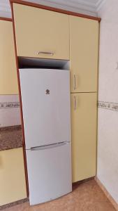 a white refrigerator in a kitchen next to two cabinets at La casa de Hio in Hio +12 photos