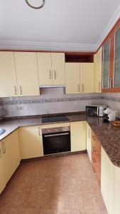 a kitchen with white cabinets and a black oven at La casa de Hio in Hio