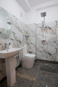 a bathroom with a sink and a toilet and a mirror at Vila e Mjeshtrit in Korçë