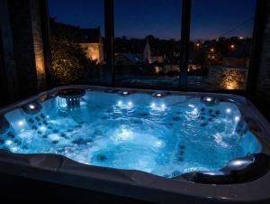 a jacuzzi tub in front of a window at night at 3 Waters Spa - Private Spa with Jacuzzi, Sauna & Hammam in Winenne