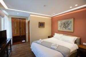a bedroom with a large bed and a television at Vila e Mjeshtrit in Korçë