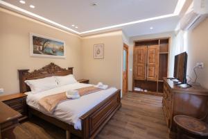 a bedroom with a bed with a dresser and a television at Vila e Mjeshtrit in Korçë +32 photos