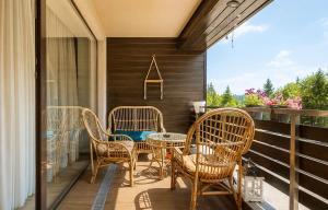 a patio with wicker chairs and a table on a porch at TIAM Apartment Poiana Brașov D117, 3 rooms, 3 terraces, 3 bathrooms in Poiana Brasov