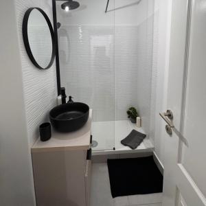 a bathroom with a black sink and a mirror at Olt view apartament in Călimăneşti +16 photos