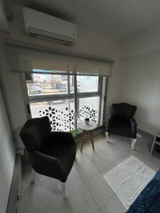 a room with two chairs and a table and a window at Apart Luro VI in Santa Rosa