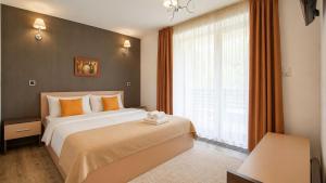 a bedroom with a large bed and a window at TIAM Apartment Poiana Brașov D117, 3 rooms, 3 terraces, 3 bathrooms in Poiana Brasov