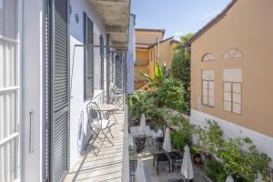 a balcony with tables and chairs on a building at Caffè dell'Arte Boutique Rooms Locarno in Locarno