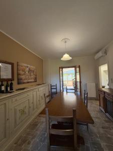 a kitchen and dining room with a wooden table at Cindy Cottage Holiday Home in Giuncarico +31 photos