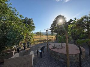 a garden with chairs and a table and trees at Cindy Cottage Holiday Home in Giuncarico