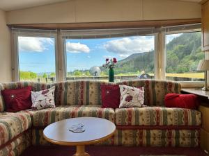 a living room with a couch and a table at Cosalt Sea View 18 in Ardentinny