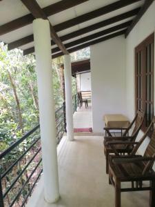 a porch with chairs and a table on it at Makelioya Nature Resort in Kelinkanda
