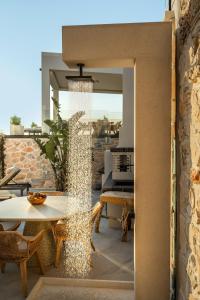a glass wall on a patio with a table and chairs at Sunset Dream Luxury Villa in Keri