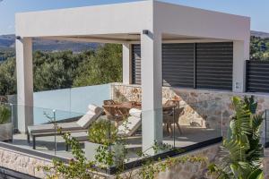 a patio with a table and chairs on a house at Sunset Dream Luxury Villa in Keri