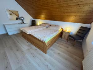 a bedroom with a large bed and a chair at Corinnas Ferienwohnung in Büdingen