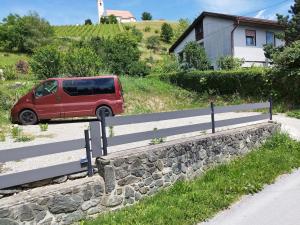 a red van parked next to a stone wall at Signature events in Malečnik