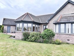 a house with a large window on the front of it at Golf View, Cruden Bay in Cruden Bay