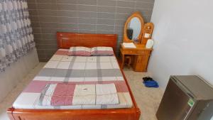 a small bedroom with a bed and a mirror at Hotel Hương Phong in Binh Chau