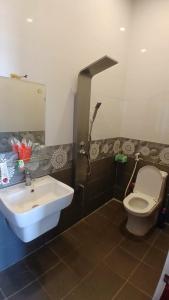 a bathroom with a sink and a toilet and a mirror at Hotel Hương Phong in Binh Chau