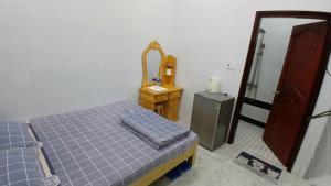 a bedroom with a bed and a dresser and a mirror at Hotel Hương Phong in Binh Chau