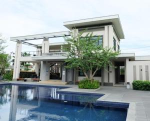 a house with a swimming pool in front of a building at Balina-Blume in Kathu