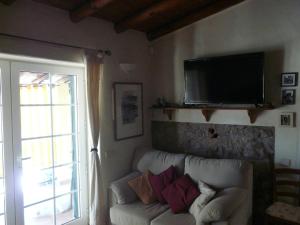 a living room with a couch and a flat screen tv at Casa do Castelão in Loulé