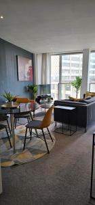 a living room with a couch and a table and chairs at Nirankaar peace 1bhk in Birmingham