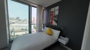 a bedroom with a white bed and a large window at Nirankaar peace 1bhk in Birmingham