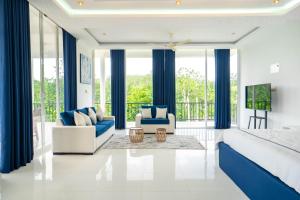 a bedroom with a king sized bed and blue curtains at Monara Villa in Dharga Town
