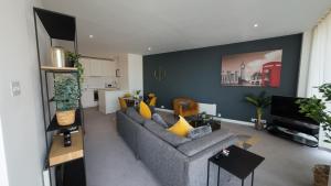 a living room with a gray couch and yellow pillows at Nirankaar peace 1bhk in Birmingham