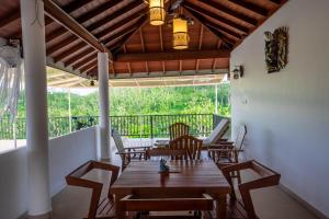 a dining room with tables and chairs and a balcony at Monara Villa in Dharga Town