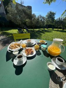 a table with plates of food and a pitcher of orange juice at Hotel Le Moulin du Château in Saint-Laurent-du-Verdon