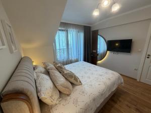 a bedroom with a bed and a couch with pillows at Limani Vasiliko in Tsarevo +64 photos